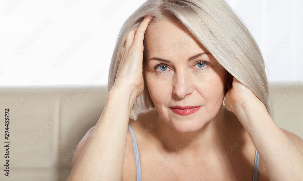 Obraz premium Portrait of cheerful senior woman smiling while looking away at spa. Happy mature woman after spa massage and anti-aging treatment on face. Realistic images with their own imperfections.