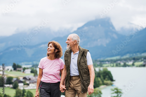 Cuadro en lienzo A senior pensioner couple hiking in nature, holding hands.