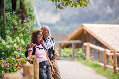 A senior pensioner couple with binoculars hiking, resting. Copy space.