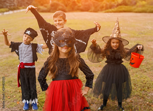 Adorable kids in carnival costumes playing on nature background