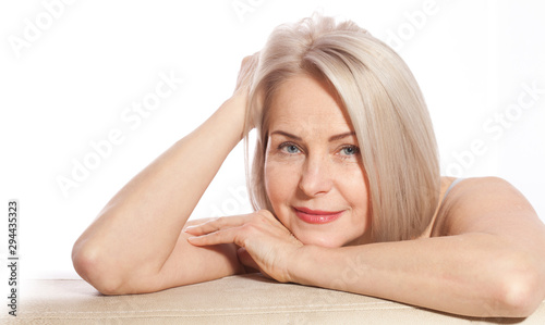 Portrait of cheerful senior woman smiling while looking away at spa. Happy mature woman after spa massage and anti-aging treatment on face. Realistic images with their own imperfections. photo