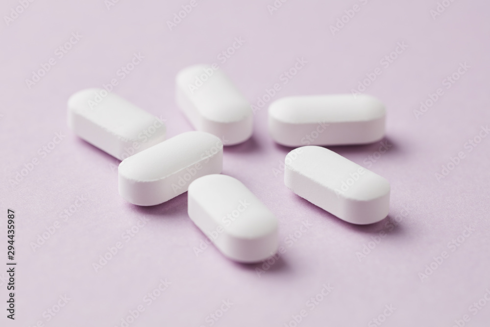 Magnesium with Vitamin B6 Tablets on pink paper background. Dietary supplement. Close up. Copy space. Magnesium with Vitamin B6 Tablets on pink paper background. Dietary supplement. Close up. Copy space.