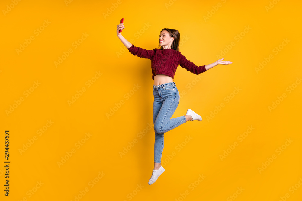 Full length profile side photo of cheerful cute girl offer holiday making photos wearing maroon sweater isolated over yellow background