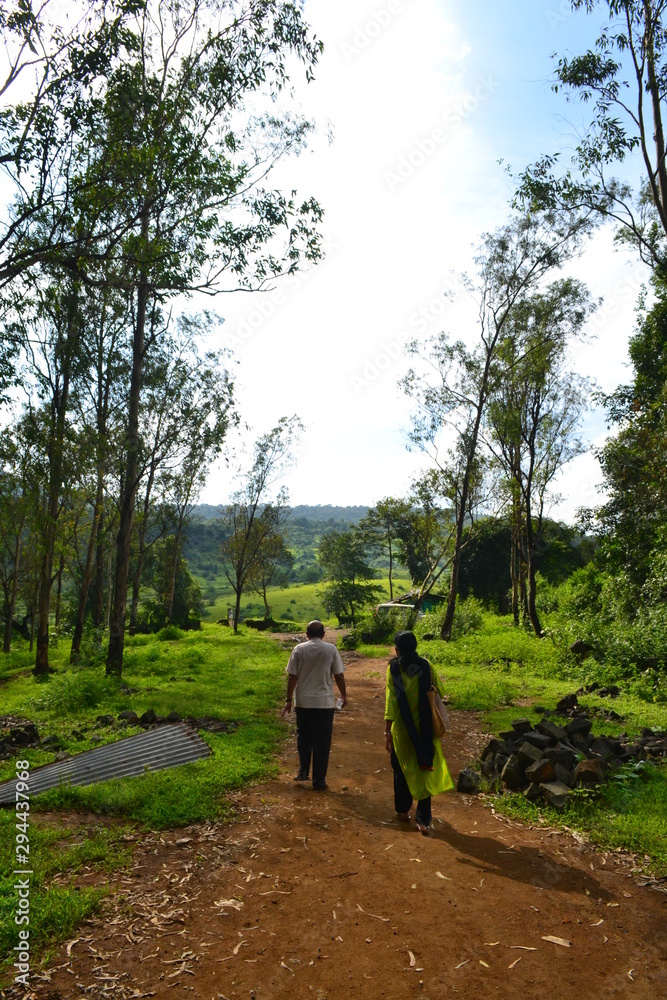 old couple walking on beautiful road in forest and mountain 