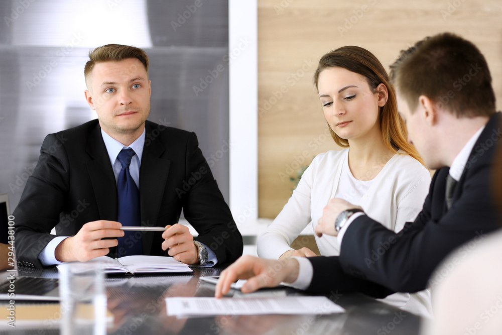 Business people or lawyers discussing questions at meeting in modern office. Unknown businessman and woman with colleague sitting and working at the glass desk. Teamwork and partnership concept Business people or lawyers discussing questions at meeting in modern office. Unknown businessman and woman with colleague sitting and working at the glass desk. Teamwork and partnership concept