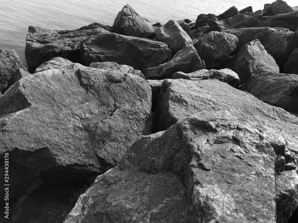 Granite stones on the seashore. Black-and-white photo. Contrasting, good texture. Nature pattern.