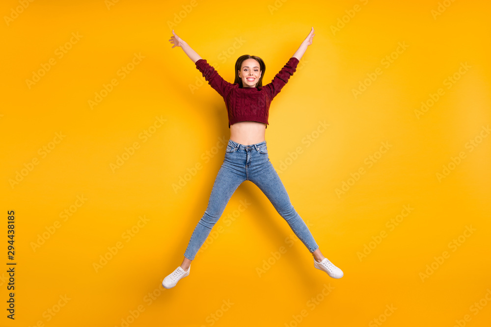 Fulll body photo of charming lady raising her arms wearing maroon pullover isolated over yellow background
