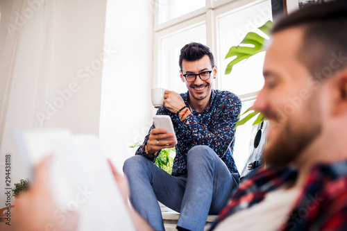 A group of young friends relaxing indoors, house sharing concept. photo