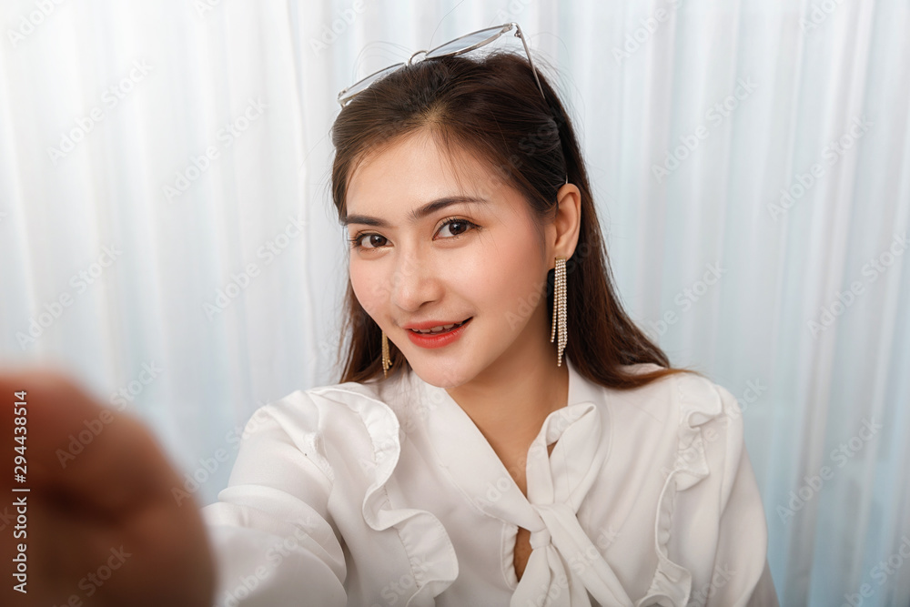 Good looking young asian woman making selfie of herself. Good looking young asian woman making selfie of herself.