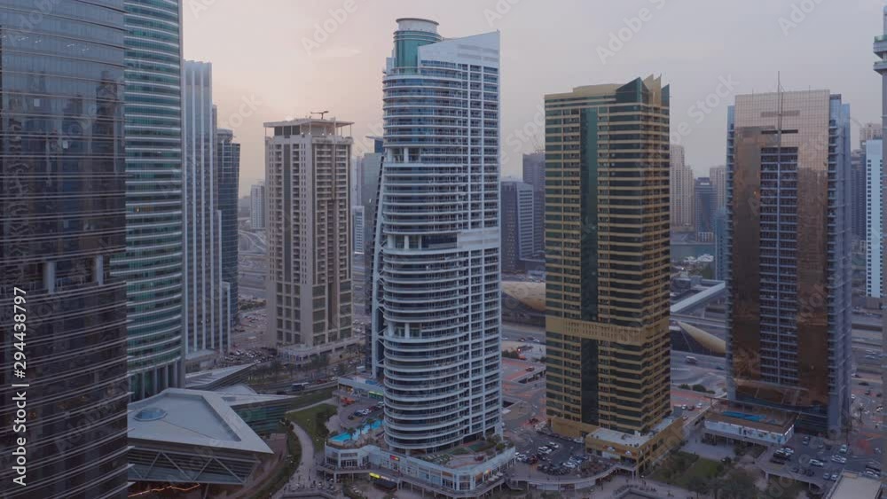 Sunset over residential and office buildings in Jumeirah lake towers district in Dubai. Aerial panoramic view from above with modern skyscrapers Sunset over residential and office buildings in Jumeirah lake towers district in Dubai. Aerial panoramic view from above with modern skyscrapers