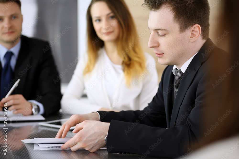 Business people or lawyers discussing questions at meeting in modern office. Unknown businessman and woman with colleague sitting and working at the glass desk. Teamwork and partnership concept Business people or lawyers discussing questions at meeting in modern office. Unknown businessman and woman with colleague sitting and working at the glass desk. Teamwork and partnership concept