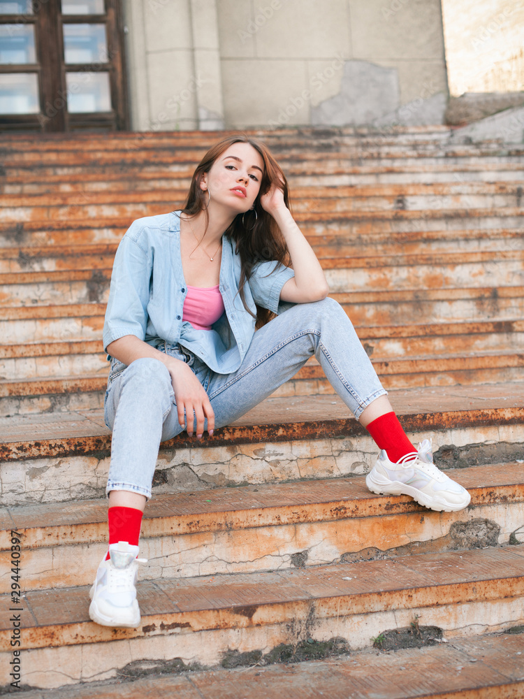 Young woman sitting on the old rusty stairs Young woman sitting on the old rusty stairs