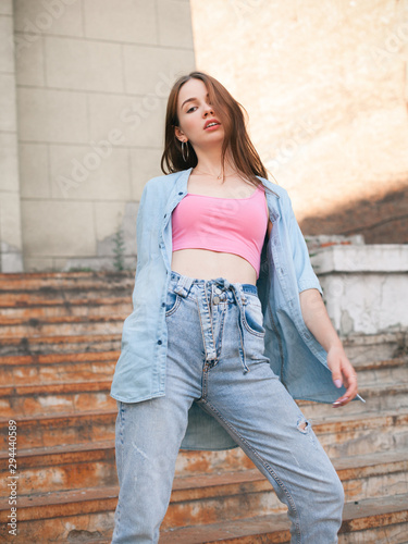 Young beautiful woman posing on the old rusty stairs
