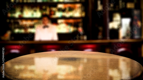 Wooden brown table of free space for your decoration and blurred background of bar. 