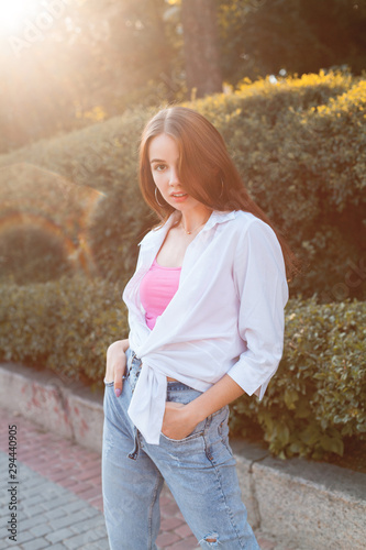 Attractive young woman posing in the park under sunlight.