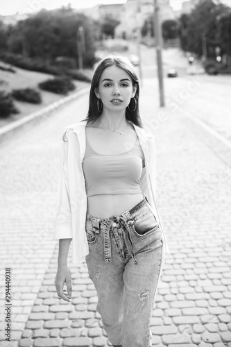 Beautiful girl with long hair walking on the street. Black and white