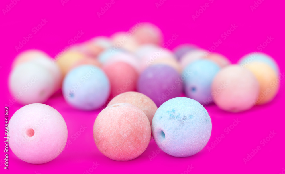 Close up of 3 beads. Set of multi-colored beads on a pink background. Blurred background Close up of 3 beads. Set of multi-colored beads on a pink background. Blurred background