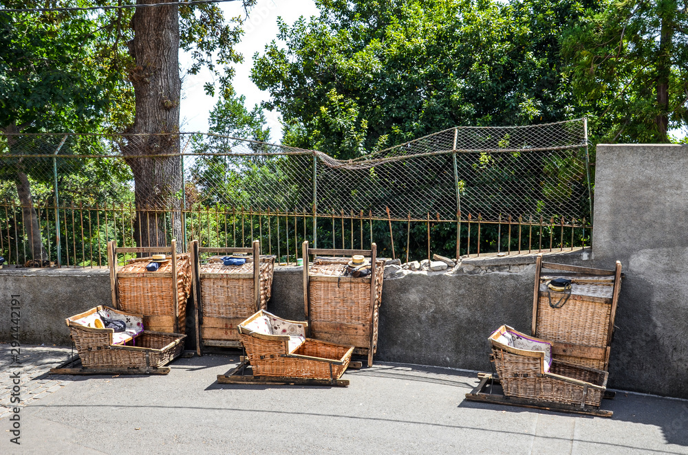 Wicker Basket Sledges in Monte, Madeira, Portugal. Traditional mean of transport between Monte and Funchal, now tourist attraction. Typical straw hats of the Carreiros drivers, with sign Madeira