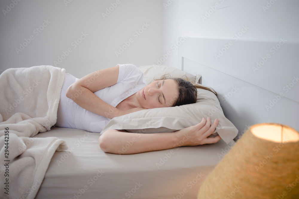 Beautiful woman sleeping on her side in her bed.