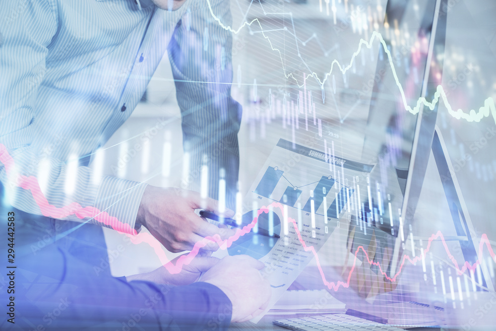 Double exposure of chart with businessman typing on computer in office on background. Concept of hard work. Double exposure of chart with businessman typing on computer in office on background. Concept of hard work.