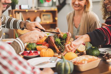 Happy Thanksgiving dinner party with family and food with turkey on table