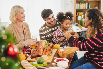 Happy Thanksgiving dinner party with family and food with turkey on table