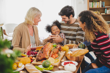 Happy Thanksgiving dinner party with family and food with turkey on table