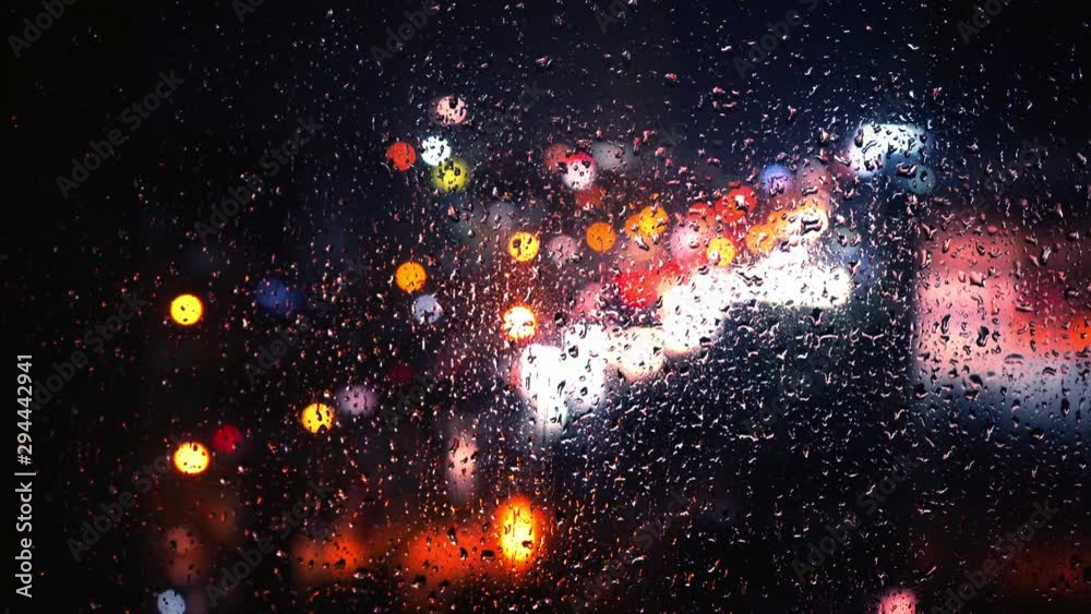 rain drop at glass window with street traffic background