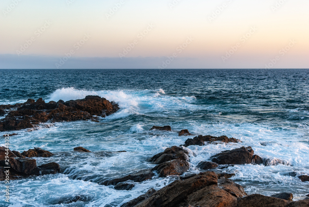 waves crash on stones canary islands, evening ocean