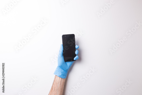 hand in glove, hand holds the phone on white background
