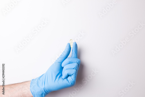 hand in glove, hand hold the pill on white background
