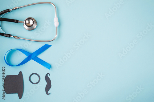  Light blue ribbons with black mustache, top hat and stethoscope on blue background, prostate cancer awareness, Movember Men health awareness, November blue. copy space.