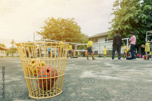 The takraws in the plastic basket on the cement floor beside the field is used for students to practice in the physical education hours.