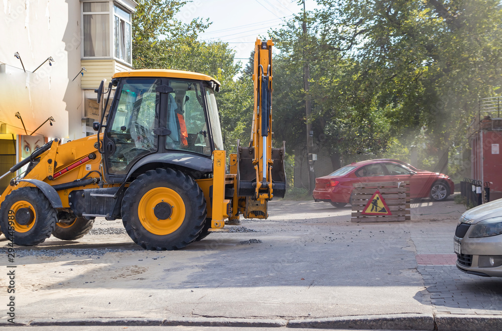 Orange excavator on wheels works in the city Orange excavator on wheels works in the city