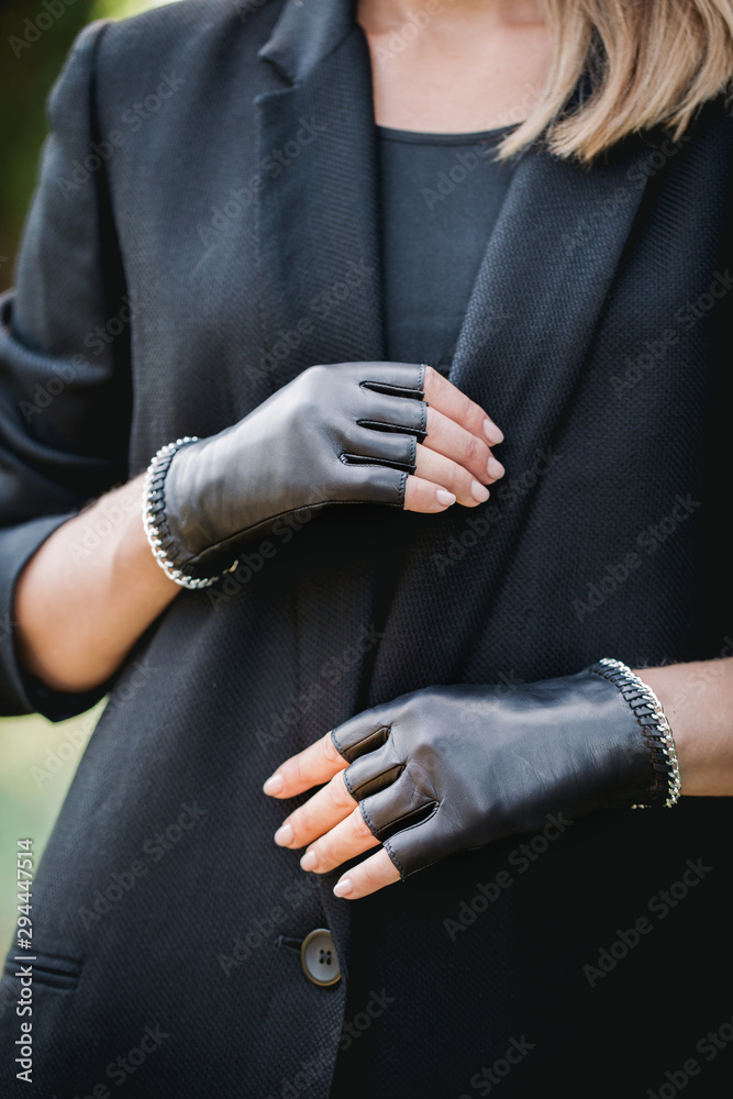 woman in a black jacket and gloves with a chain, close-up woman in a black jacket and gloves with a chain, close-up