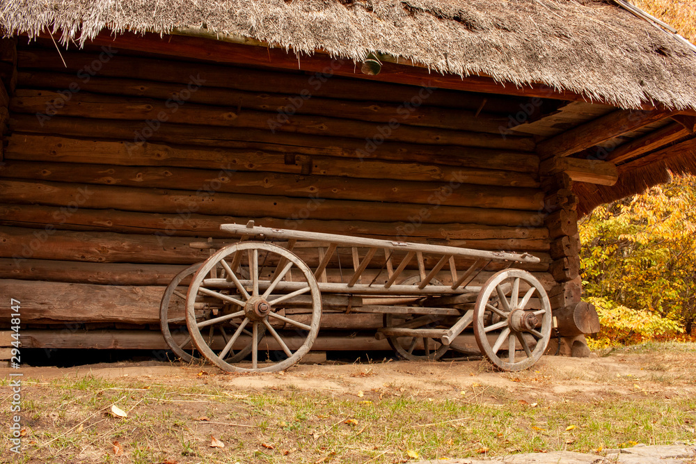 Obraz premium Old wooden cart in front of an old barn. Rural landscape