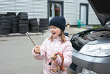 A child mechanic works in a garage, outdoors.  Car repair services.  Car service.