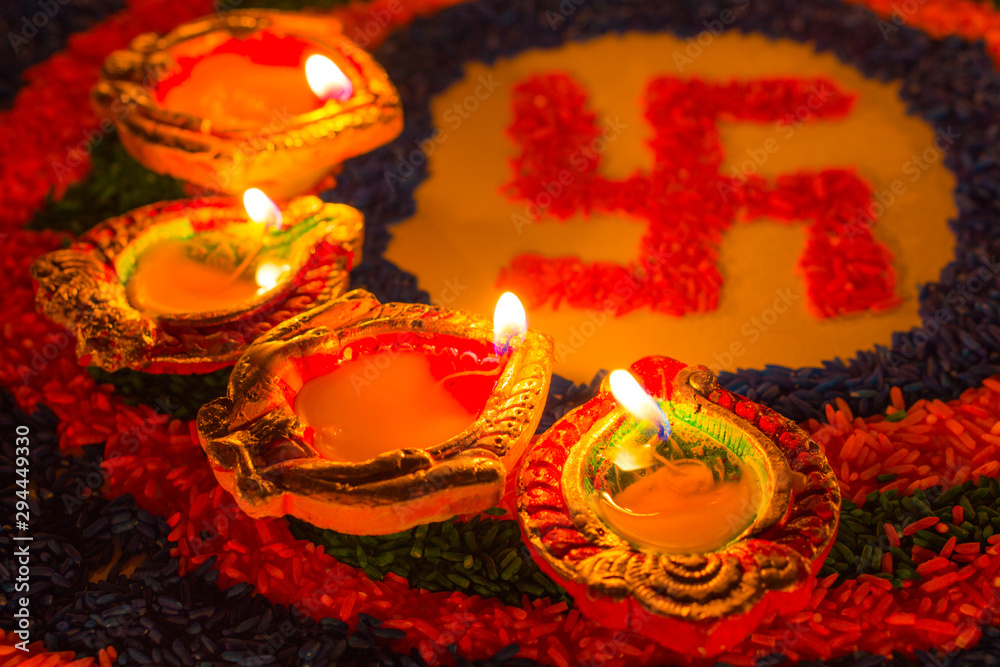 Indian festival Diwali, Diya oil lamps lit on colorful rangoli with  Swastika symbol. Hindu traditional. Happy Deepavali. Stock Photo | Adobe  Stock