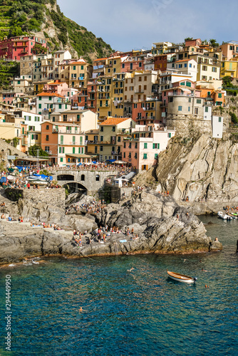 Manarola, Cinque Terre, Italy - August 17, 2019: Picturesque village in the province of La Spezia. Colorful houses on the coastal cliffs. Ligurian Sea Bay with moored boats