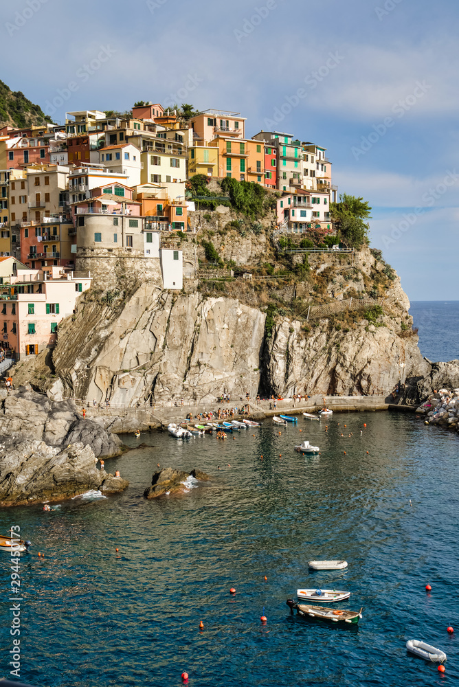 Manarola, Cinque Terre, Italy - August 17, 2019: Picturesque village in the province of La Spezia. Colorful houses on the coastal cliffs. Ligurian Sea Bay with moored boats