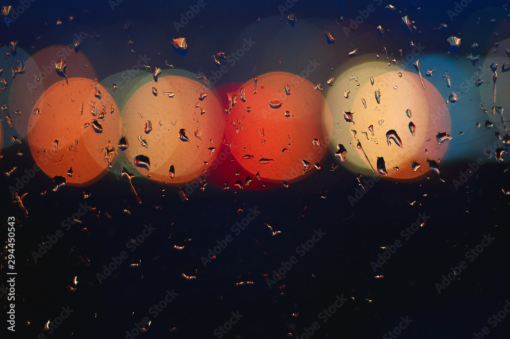 Fototapeta premium Light of lanterns in blurry background with raindrops on glass