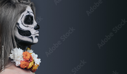 Spooky female with painted face and flowers