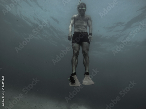 Underwater swimming  over sunlight rays photo