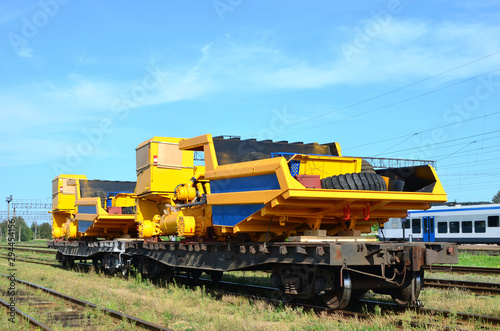 Logistics transportation heavy mining dump truck by rail. Yellow mining truck disassembled into parts, cab, body, electric motor, drive, wheels, loaded onto a cargo railway platform.