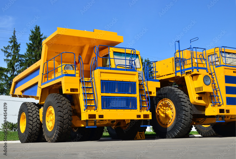 Heavy-duty trucks warehouse at autoworks. Big mining dump truck manufacture by the heavy vehicle plant. Coal mining, granite, gravel, sand.