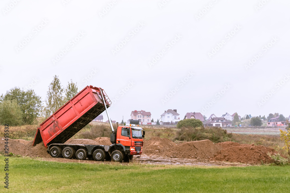 Fototapeta premium A large 70-ton dump truck brought sand to a new construction site to add land