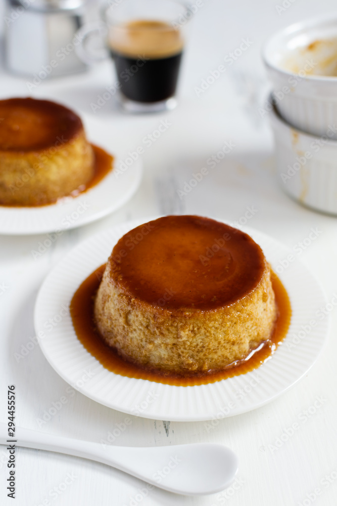 Caramel flan, crema catalana dessert on white woden table Caramel flan, crema catalana dessert on white woden table