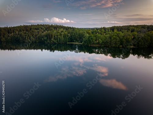 Clouds reflect in a perfectly still lake on a calm summer evening