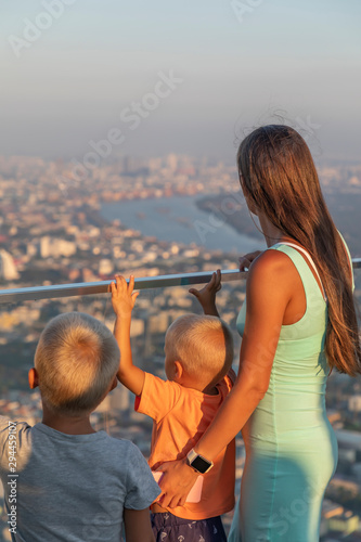 Fototapeta Naklejka Na Ścianę i Meble -  young beautiful mother with children on a bangkok skyscraper