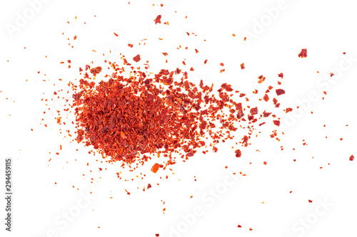 Fototapeta Close-up shot of crushed red chili pepper flakes isolated on white background, top view